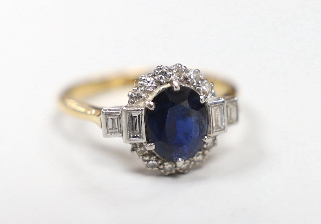 An Art Deco 18ct and plat, sapphire and diamond set oval dress ring with baguette cut diamond set shoulders, size P, gross weight 4.5 grams, in Art Deco celluloid box.